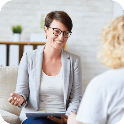 Female mental health professional smiling while helping a patient.