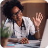 Happy African American doctor waving while making a video call over laptop.