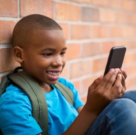 School boy looking at his cell phone.