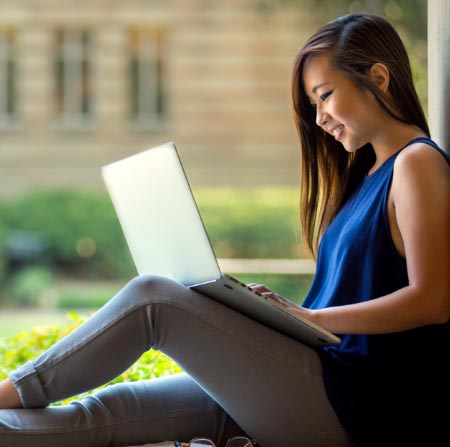 Girl sitting outside using her laptop.