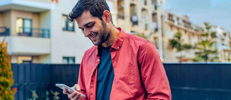 Smiling man looking at his phone.