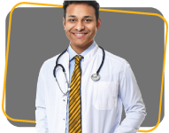 Smiling male doctor wearing a lab coat and a yellow tie with a stethoscope around his neck.